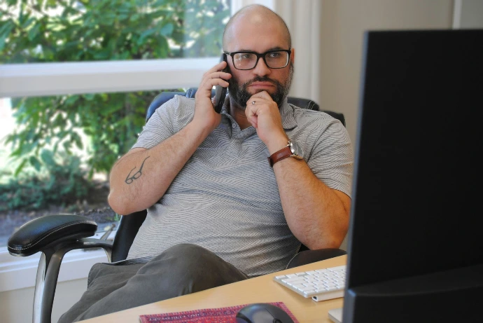 Man staring at computer on the phone